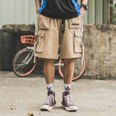 Hip hop men shorts beige cotton cargo style with multiple pockets and side straps worn with sneakers and socks